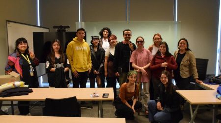 En la foto aparece el grupo de estudiantes que organizó el ciclo de talleres Impostores en la U. Están todos de pie, adelante de un pizarrón.